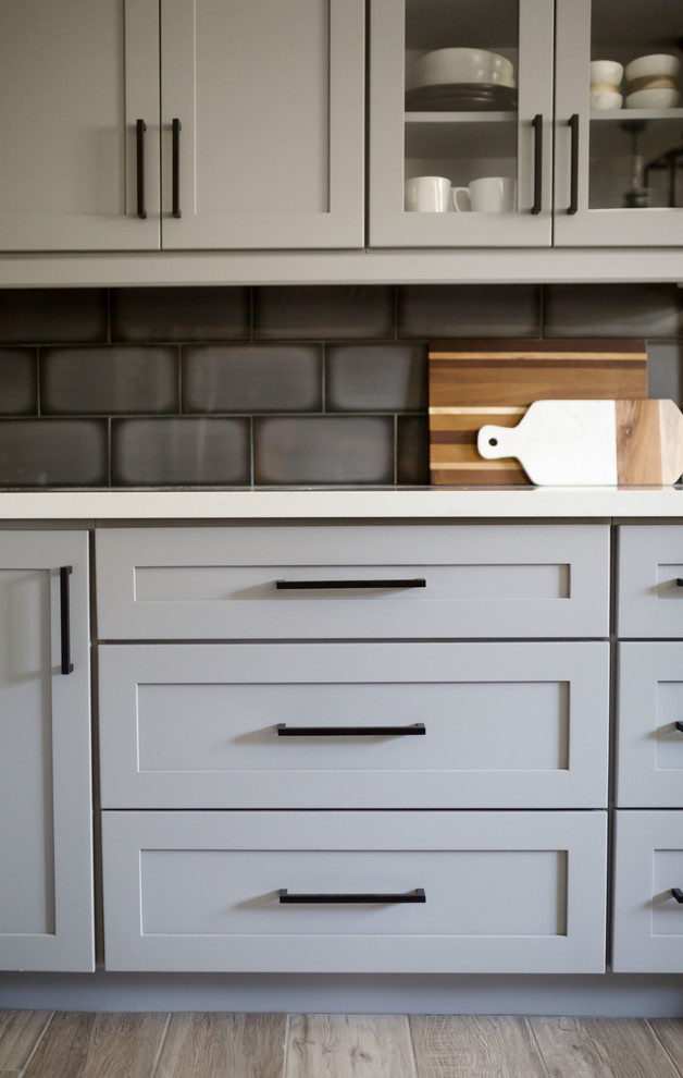 Inspiration for a mid-sized transitional u-shaped light wood floor and gray floor eat-in kitchen remodel in Phoenix with an undermount sink, recessed-panel cabinets, gray cabinets, quartz countertops, multicolored backsplash, ceramic backsplash, stainless steel appliances, an island and white countertops