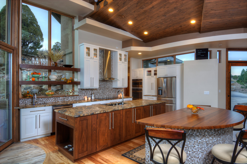 Large transitional u-shaped medium tone wood floor eat-in kitchen photo in Denver with shaker cabinets, white cabinets, multicolored backsplash, stainless steel appliances and two islands