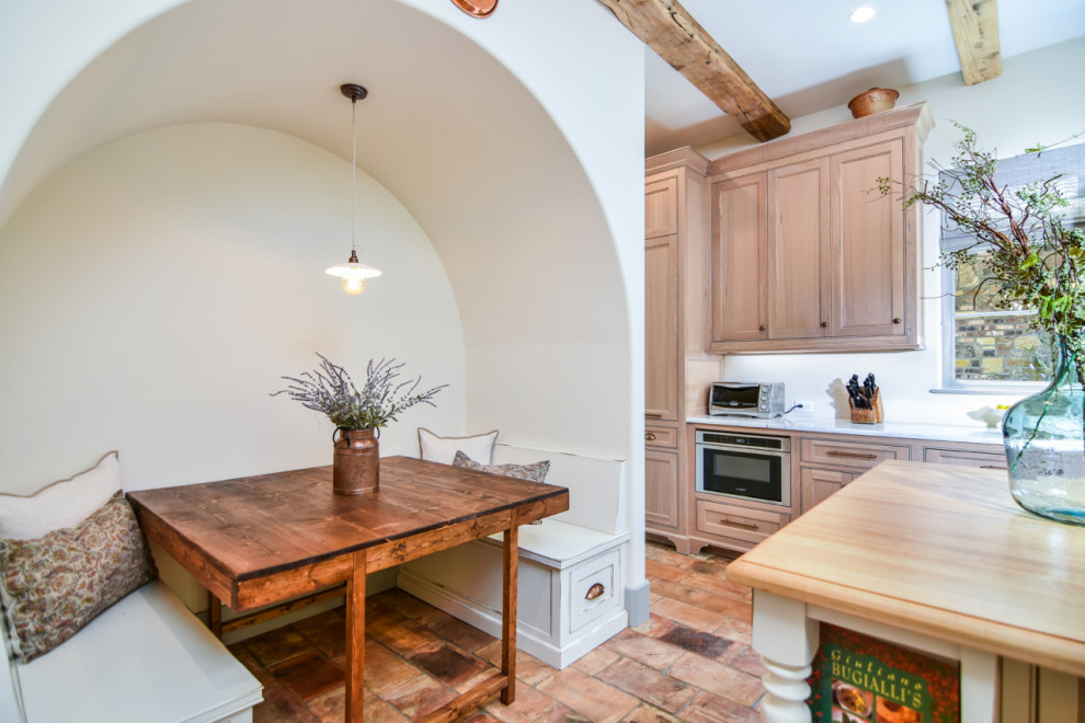 Mid-sized mediterranean single-wall open plan kitchen in Other with a farmhouse sink, beaded inset cabinets, medium wood cabinets, wood benchtops, panelled appliances, terra-cotta floors, with island, multi-coloured floor and multi-coloured benchtop.