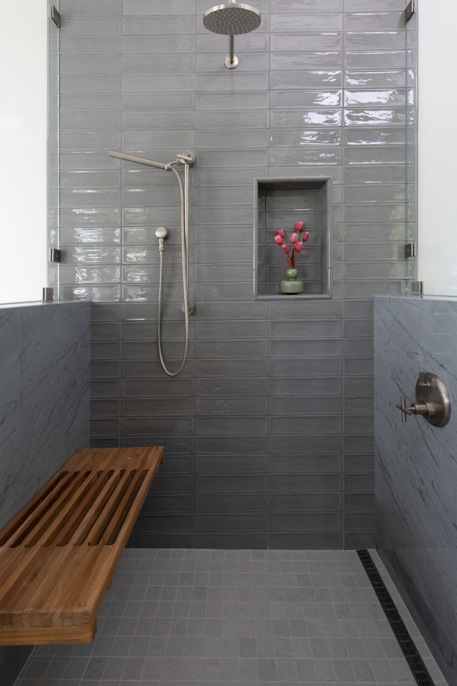 Inspiration for a large beach style bathroom in Los Angeles with flat-panel cabinets, light wood cabinets, a japanese tub, an alcove shower, a one-piece toilet, gray tile, glass tile, grey walls, marble floors, a vessel sink, marble benchtops, grey floor, grey benchtops, a shower seat, a single vanity and a floating vanity.