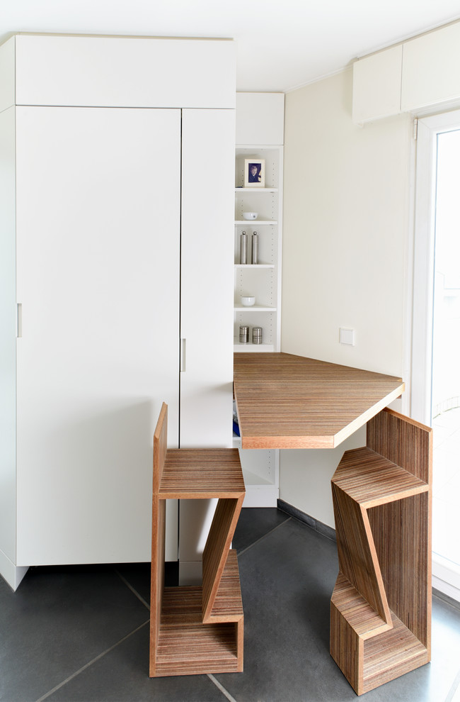 This is an example of a modern kitchen in Amsterdam with flat-panel cabinets and dark wood cabinets.