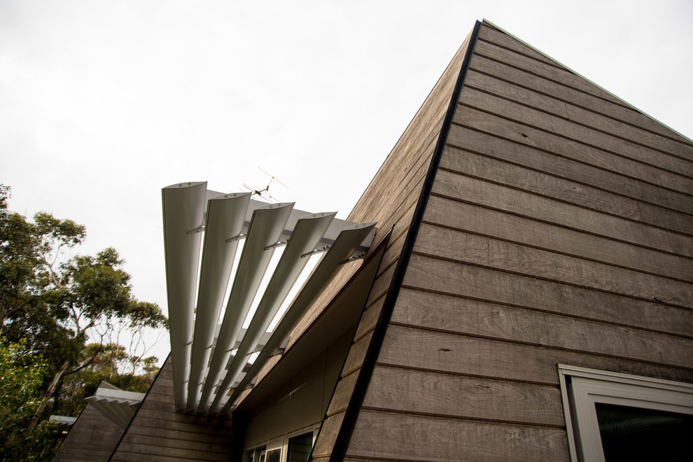Photo of a mid-sized contemporary one-storey grey exterior in Melbourne with wood siding.