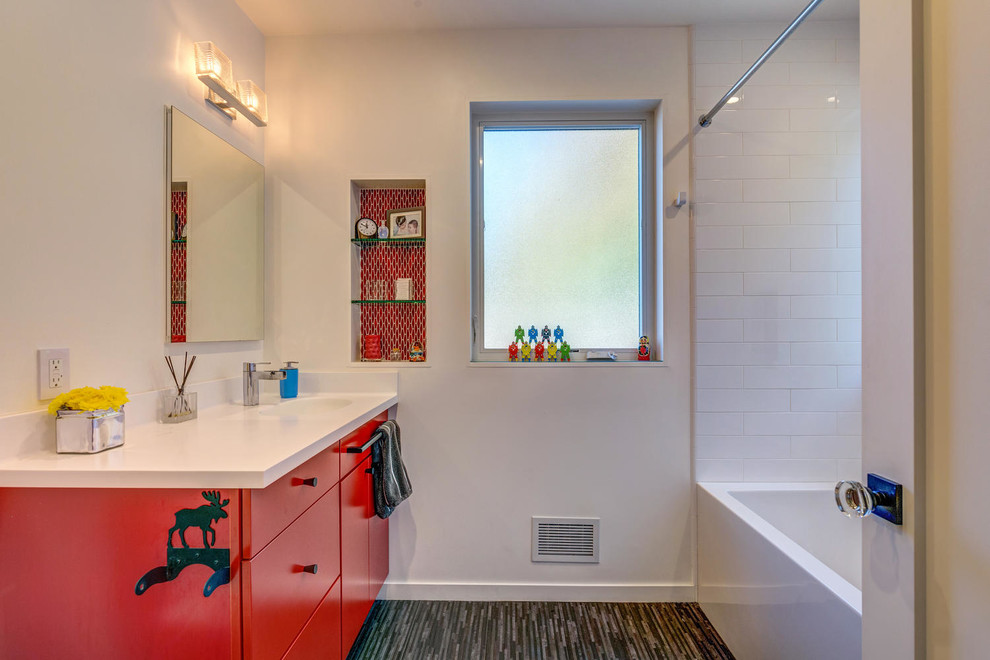 Photo of a mid-sized contemporary kids bathroom in Los Angeles with flat-panel cabinets, red cabinets, an alcove tub, a shower/bathtub combo, white tile, subway tile, white walls, mosaic tile floors, an integrated sink, engineered quartz benchtops, grey floor and a shower curtain.