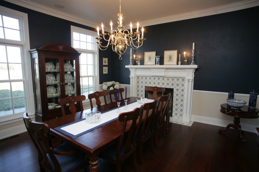 Photo of a large traditional separate dining room in Other with blue walls, dark hardwood floors, a standard fireplace and a tile fireplace surround.