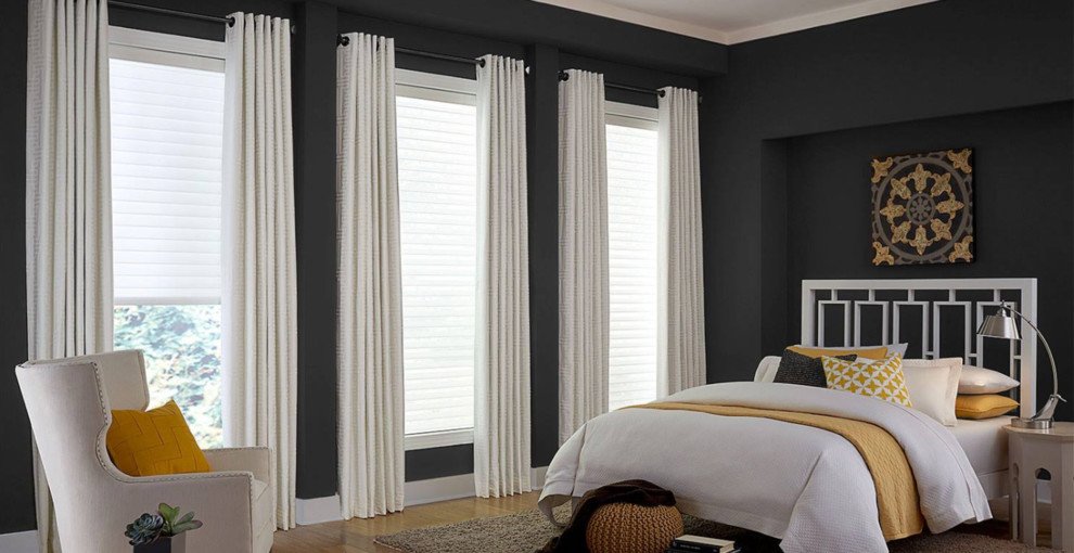Large transitional master bedroom in Los Angeles with grey walls, dark hardwood floors and brown floor.