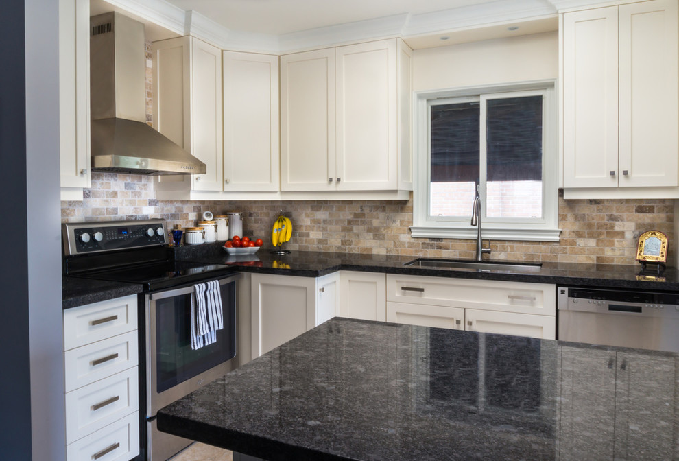 Example of a mid-sized transitional u-shaped ceramic tile enclosed kitchen design in Toronto with an undermount sink, shaker cabinets, white cabinets, granite countertops, beige backsplash, stainless steel appliances, brick backsplash and an island