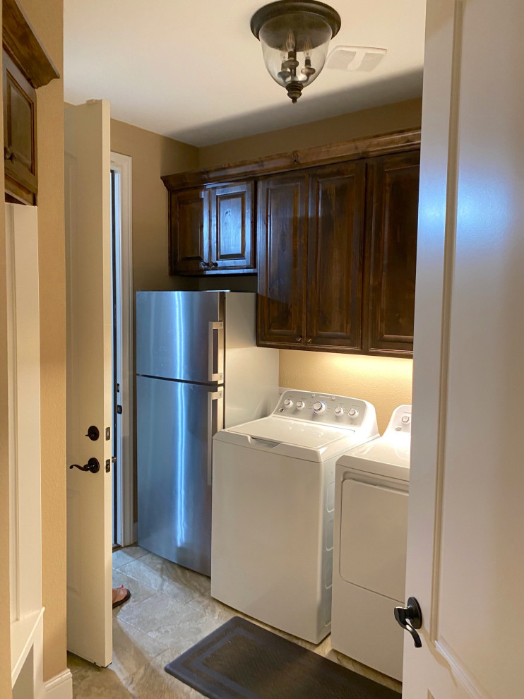 Design ideas for a mid-sized arts and crafts galley dedicated laundry room in Dallas with raised-panel cabinets, brown cabinets, brown walls, porcelain floors, a side-by-side washer and dryer and beige floor.