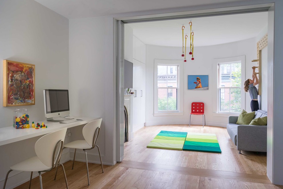 Playroom - mid-sized transitional boy medium tone wood floor playroom idea in Boston with white walls