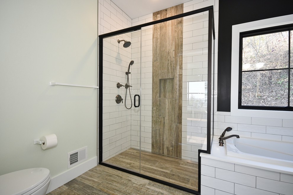 Design ideas for a mid-sized transitional master bathroom in Other with recessed-panel cabinets, black cabinets, a drop-in tub, a corner shower, a two-piece toilet, white tile, subway tile, green walls, dark hardwood floors, an undermount sink, quartzite benchtops, brown floor, a hinged shower door and white benchtops.
