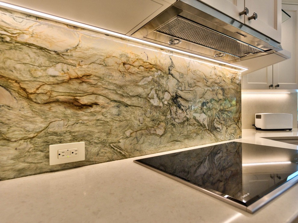 Eat-in kitchen - mid-sized transitional l-shaped medium tone wood floor eat-in kitchen idea in Miami with an undermount sink, shaker cabinets, white cabinets, quartzite countertops, multicolored backsplash, stone slab backsplash and stainless steel appliances