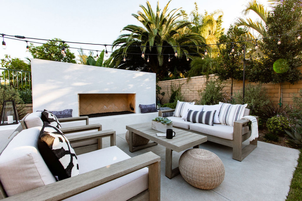 Design ideas for a contemporary patio in Orange County with with fireplace, concrete slab and no cover.