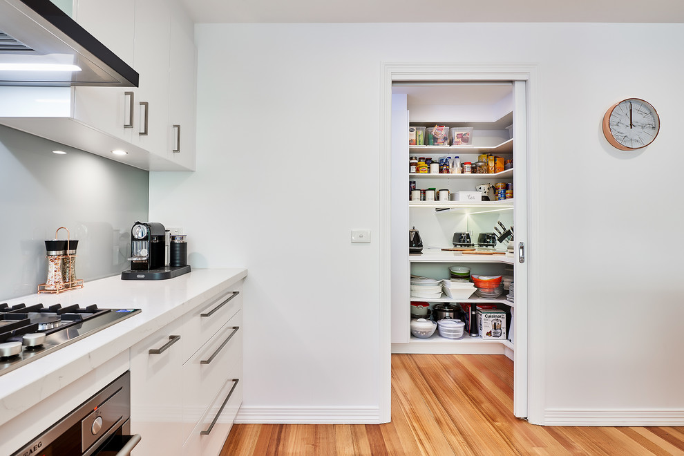 Contemporary kitchen pantry in Melbourne with open cabinets, white cabinets and mirror splashback.