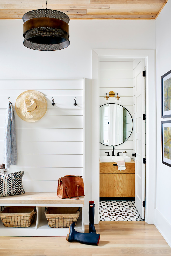 Small scandinavian entryway in Atlanta with white walls, light hardwood floors, wood and planked wall panelling.