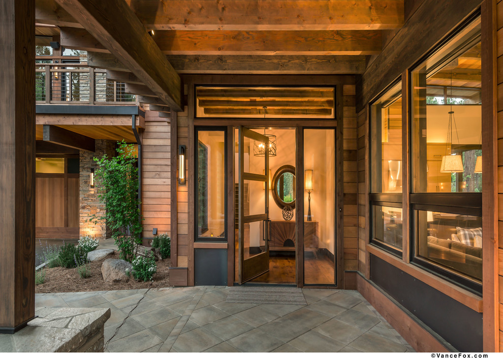 This is an example of a large transitional front door in Sacramento with black walls, dark hardwood floors, a pivot front door and a dark wood front door.