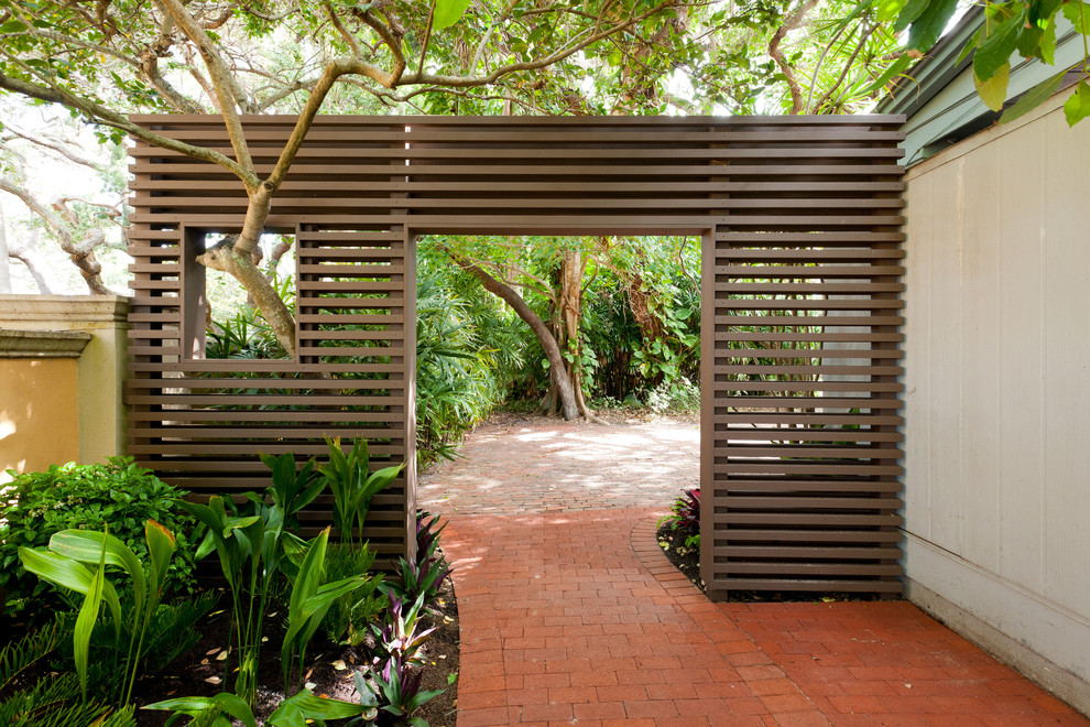 This is an example of a tropical side yard garden in Portland with brick pavers and a garden path.