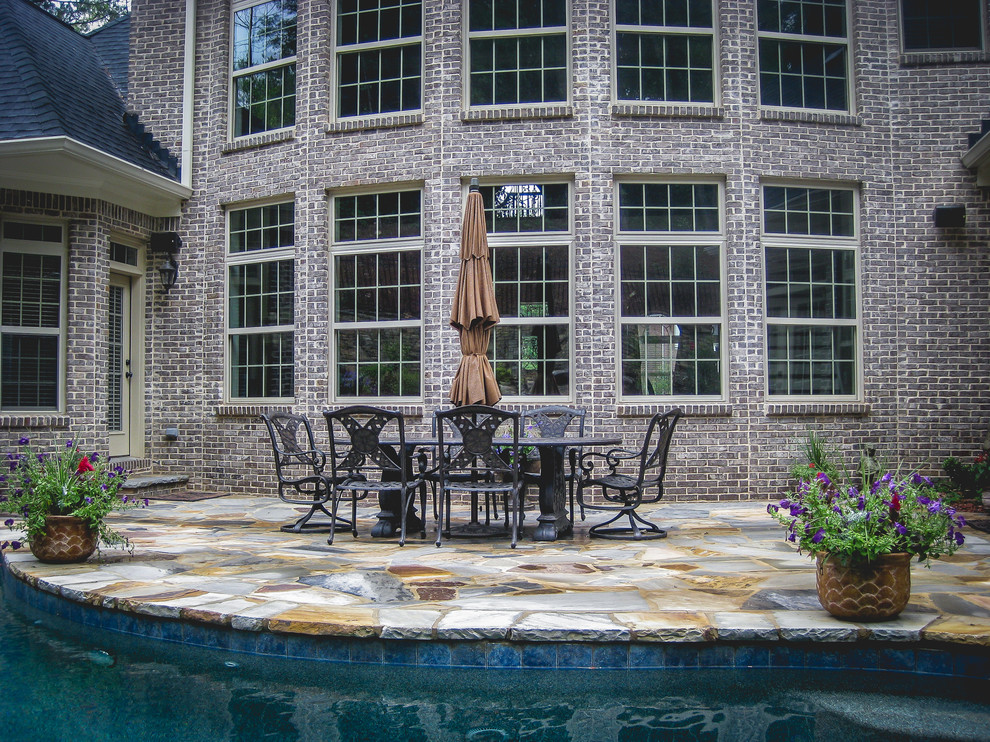 Design ideas for a mid-sized traditional backyard patio in Atlanta with natural stone pavers.