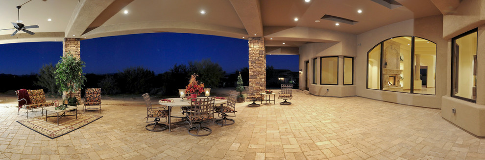 Large traditional backyard patio in Phoenix with brick pavers and a roof extension.