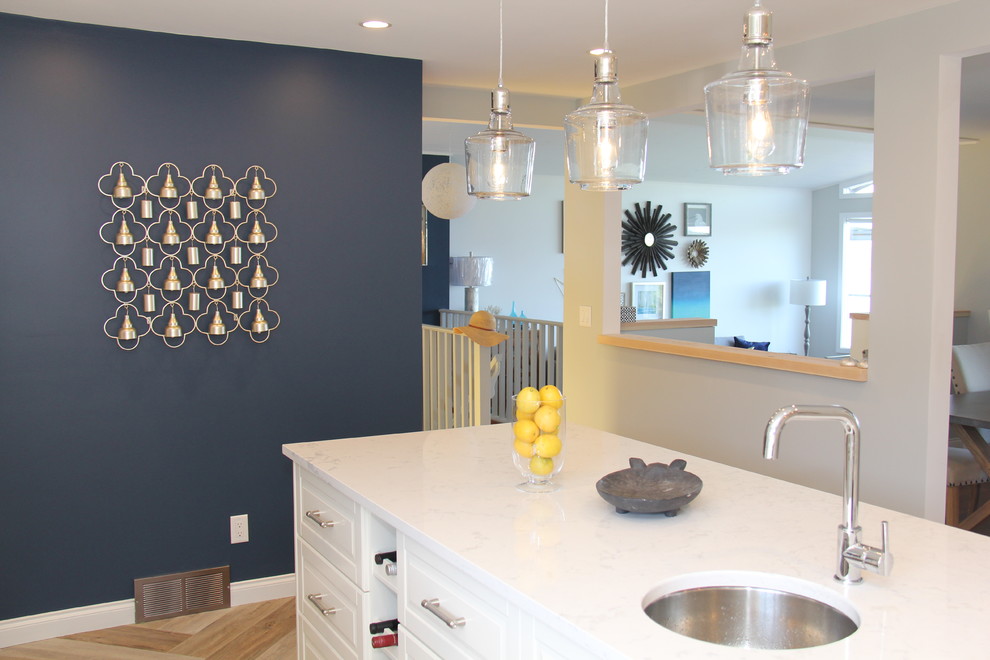 Inspiration for a large transitional l-shaped vinyl floor and brown floor open concept kitchen remodel with an undermount sink, recessed-panel cabinets, white cabinets, quartz countertops, white backsplash, ceramic backsplash, stainless steel appliances and an island