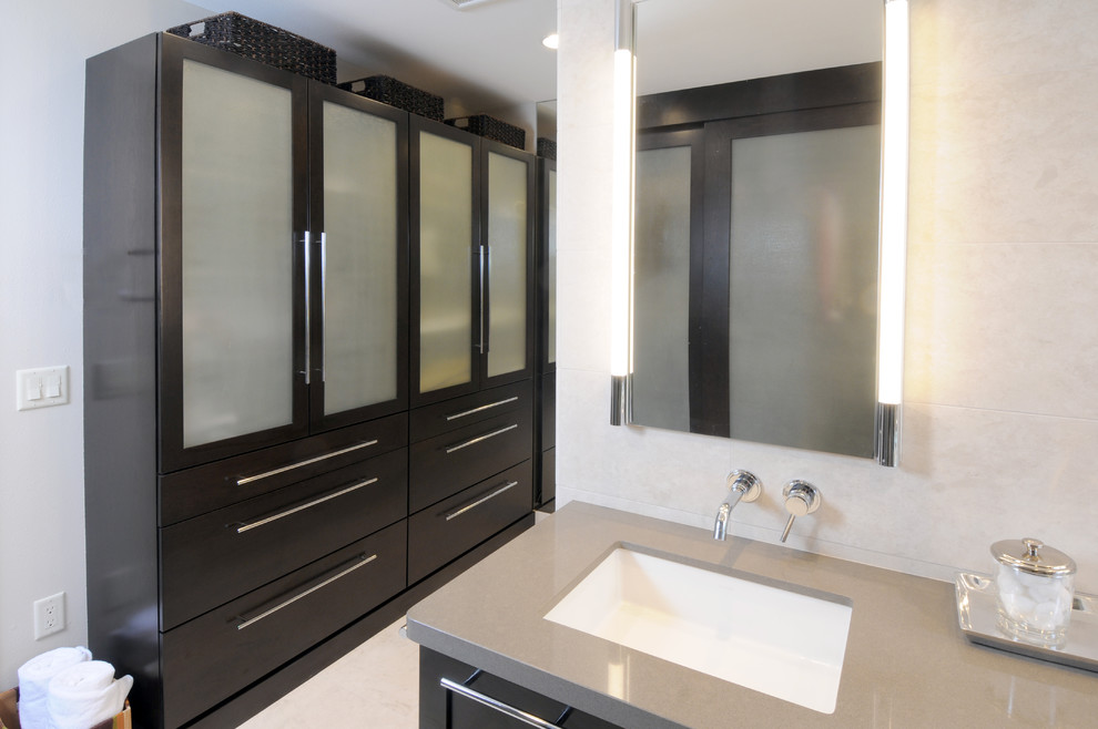 Photo of a large contemporary master bathroom in Other with shaker cabinets, dark wood cabinets, an alcove shower, a one-piece toilet, beige tile, stone tile, grey walls, travertine floors, an undermount sink and engineered quartz benchtops.