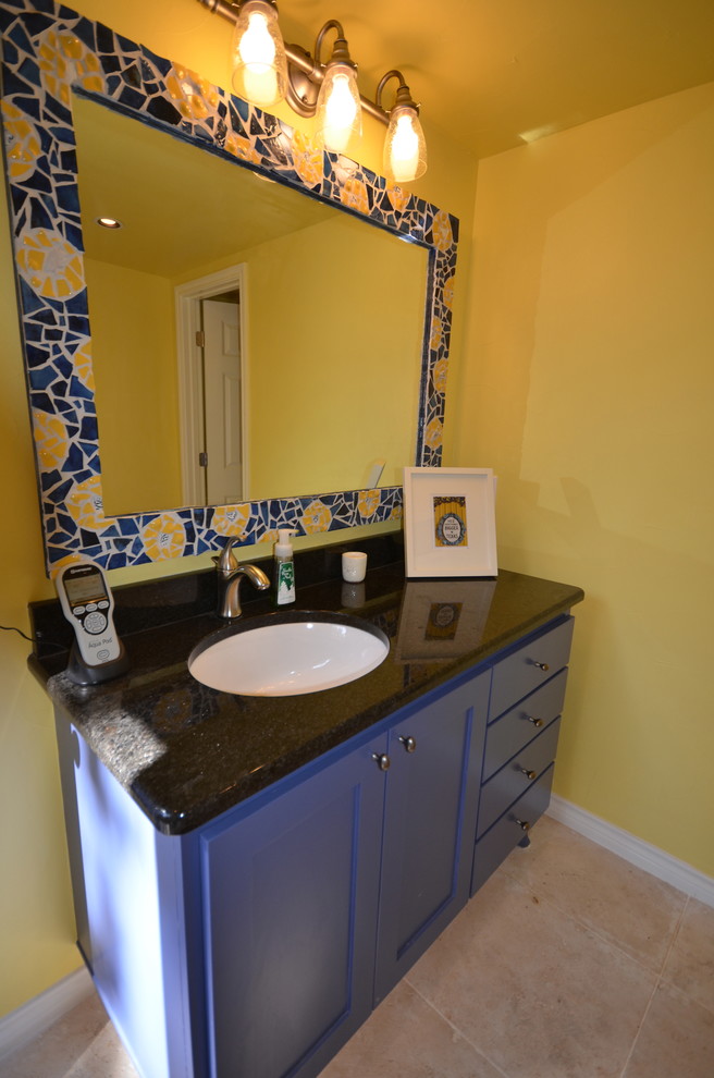 This is an example of a mid-sized mediterranean 3/4 bathroom in Austin with shaker cabinets, blue cabinets, an alcove shower, a two-piece toilet, blue tile, ceramic tile, yellow walls, travertine floors, an undermount sink, granite benchtops, beige floor and a hinged shower door.