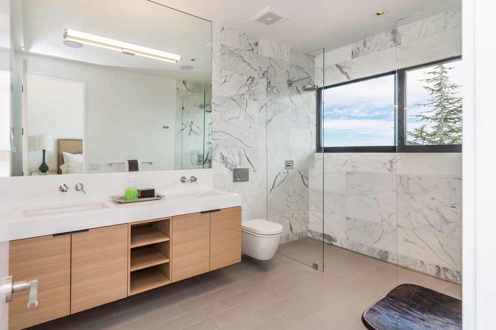 Walk-in shower - mid-sized modern master gray tile and porcelain tile ceramic tile walk-in shower idea in San Francisco with flat-panel cabinets, light wood cabinets, a wall-mount toilet, white walls, an undermount sink and quartz countertops