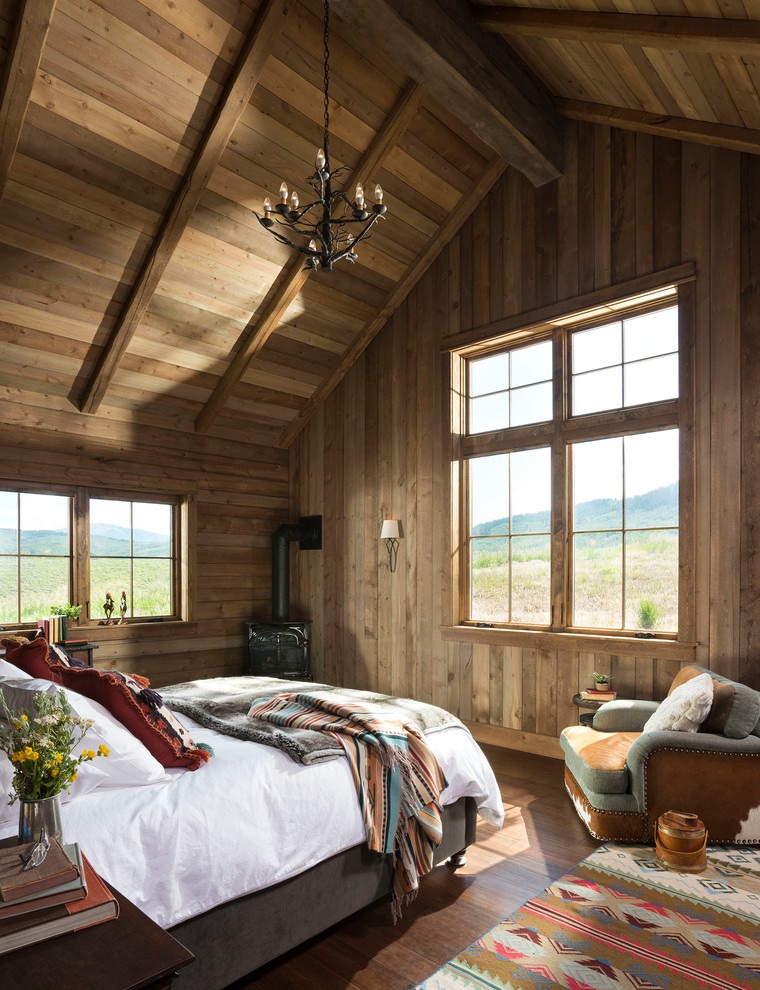 Inspiration for a country master bedroom in Boise with brown walls and a wood stove.