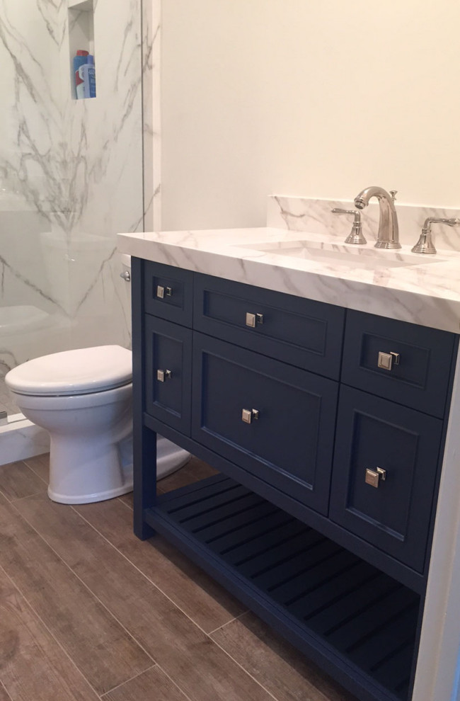 Inspiration for a mid-sized modern kids bathroom in Houston with shaker cabinets, blue cabinets, an alcove shower, a two-piece toilet, white tile, white walls, cement tiles, an undermount sink, solid surface benchtops, brown floor, a hinged shower door, white benchtops, a single vanity and a freestanding vanity.
