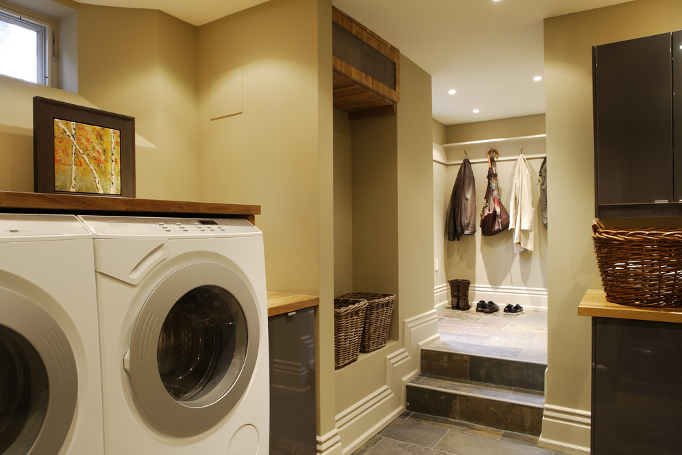 Traditional laundry room in Toronto with wood benchtops.