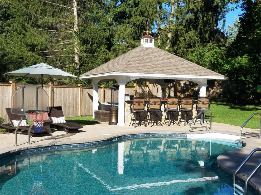 Photo of a large traditional backyard patio in Philadelphia with an outdoor kitchen, a gazebo/cabana and natural stone pavers.