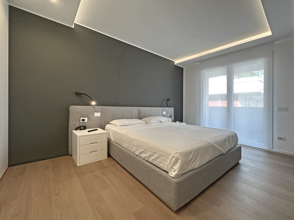 Идея дизайна: хозяйская спальня среднего размера в стиле модернизм с разноцветными стенами, светлым паркетным полом, коричневым полом, многоуровневым потолком и телевизором