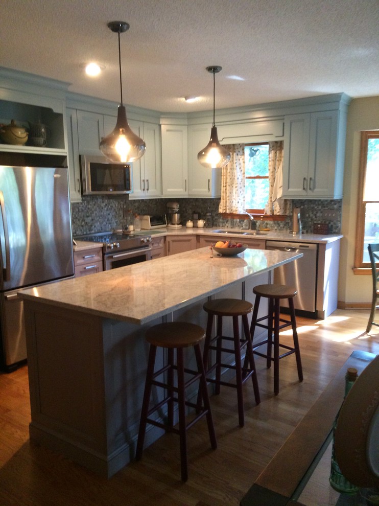 Inspiration for a mid-sized transitional l-shaped light wood floor and beige floor open concept kitchen remodel with a double-bowl sink, recessed-panel cabinets, blue cabinets, multicolored backsplash, matchstick tile backsplash, stainless steel appliances, an island and granite countertops