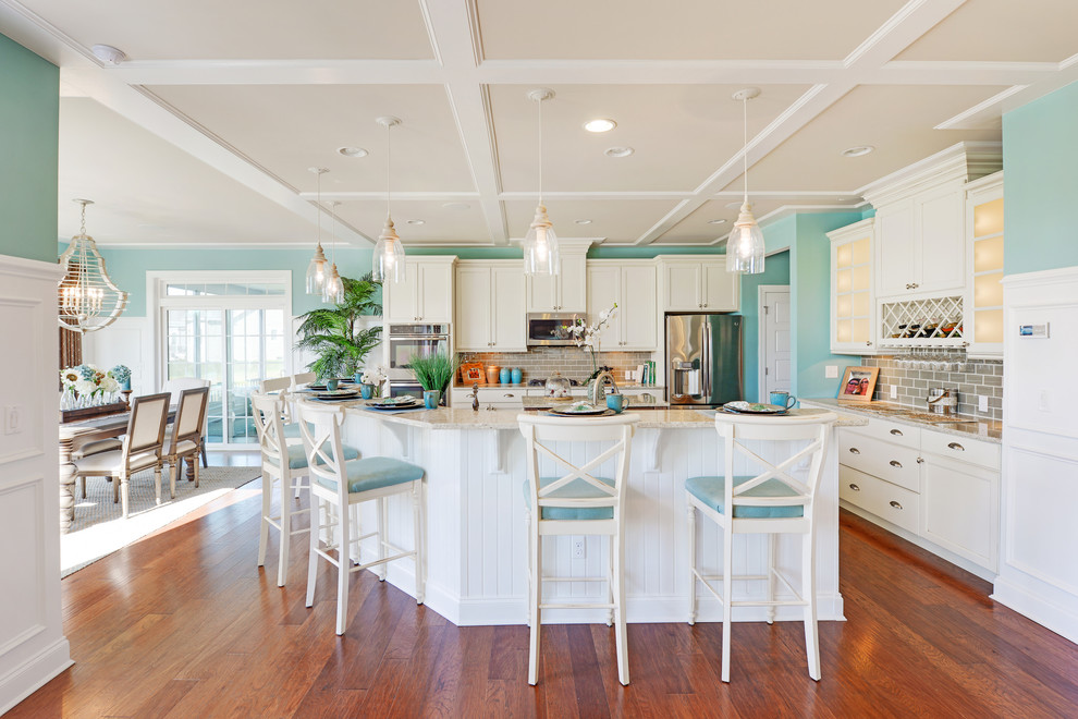Photo of a beach style l-shaped kitchen in Philadelphia with an undermount sink, shaker cabinets, white cabinets, grey splashback, stainless steel appliances, dark hardwood floors and with island.
