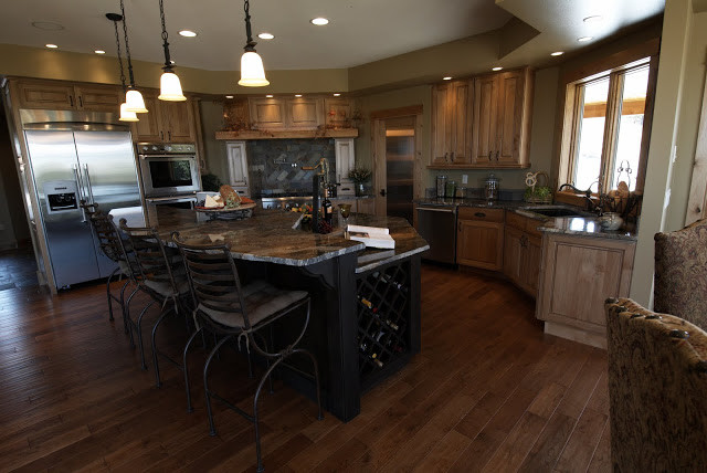 Large mountain style u-shaped medium tone wood floor open concept kitchen photo with a double-bowl sink, beaded inset cabinets, medium tone wood cabinets, granite countertops, stainless steel appliances and an island