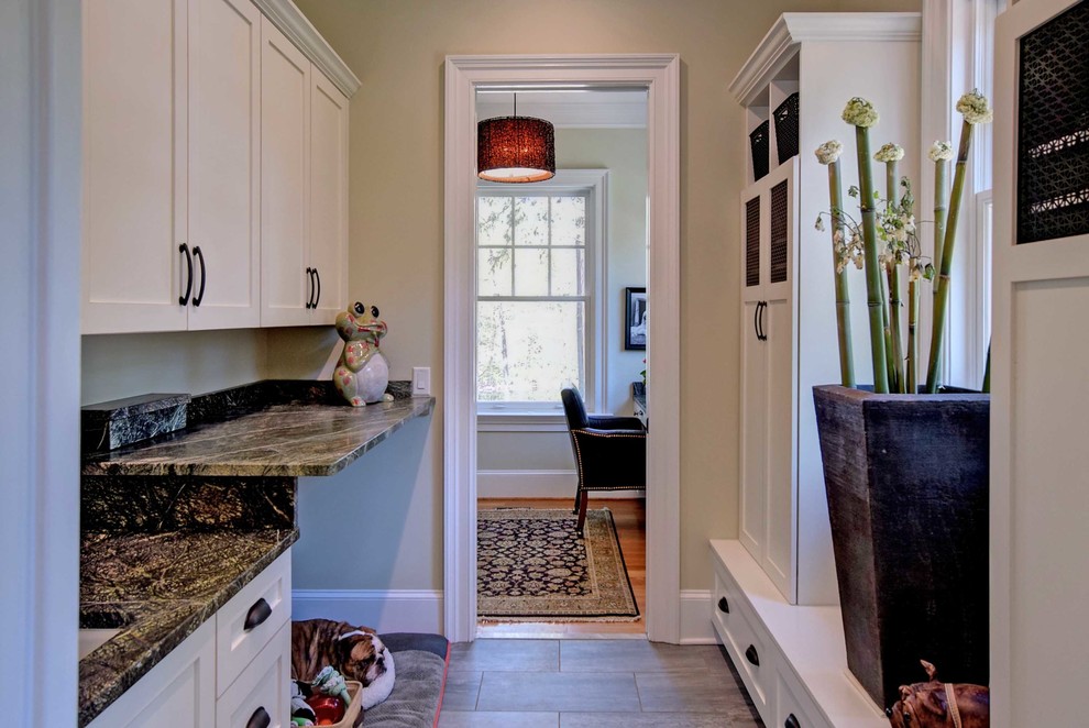 Inspiration for a transitional ceramic tile utility room remodel with an undermount sink, shaker cabinets, white cabinets, granite countertops and beige walls