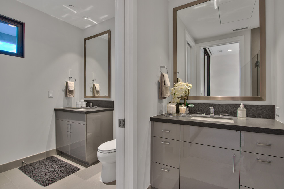 Example of a mid-sized trendy master gray floor bathroom design in Phoenix with flat-panel cabinets, gray cabinets, an undermount sink, quartz countertops and gray countertops