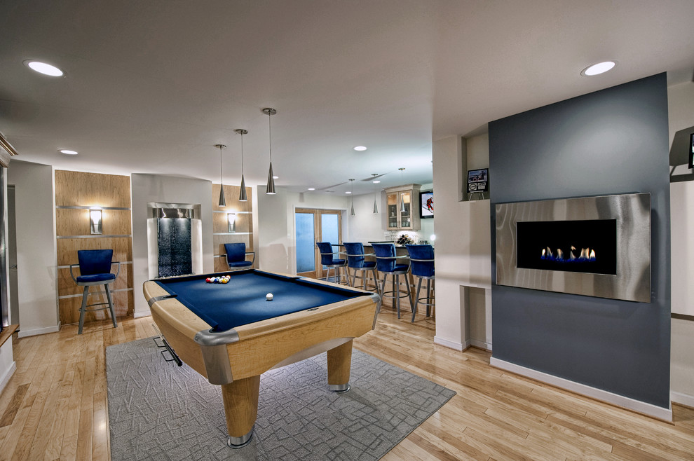 Large contemporary walk-out basement in DC Metro with blue walls, light hardwood floors, a metal fireplace surround, a ribbon fireplace and beige floor.