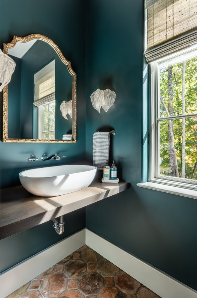 Mid-sized mediterranean powder room in Other with open cabinets, grey cabinets, green walls, terra-cotta floors, a vessel sink, wood benchtops, pink floor and grey benchtops.