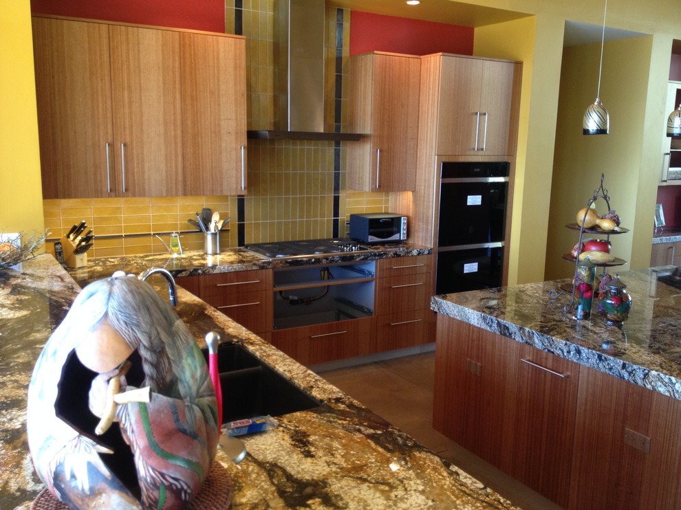 Mid-sized transitional concrete floor eat-in kitchen photo in Phoenix with an undermount sink, flat-panel cabinets, medium tone wood cabinets, granite countertops, yellow backsplash and an island