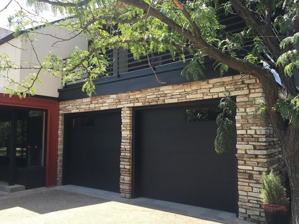 This is an example of a mid-sized contemporary attached two-car garage in Oklahoma City.