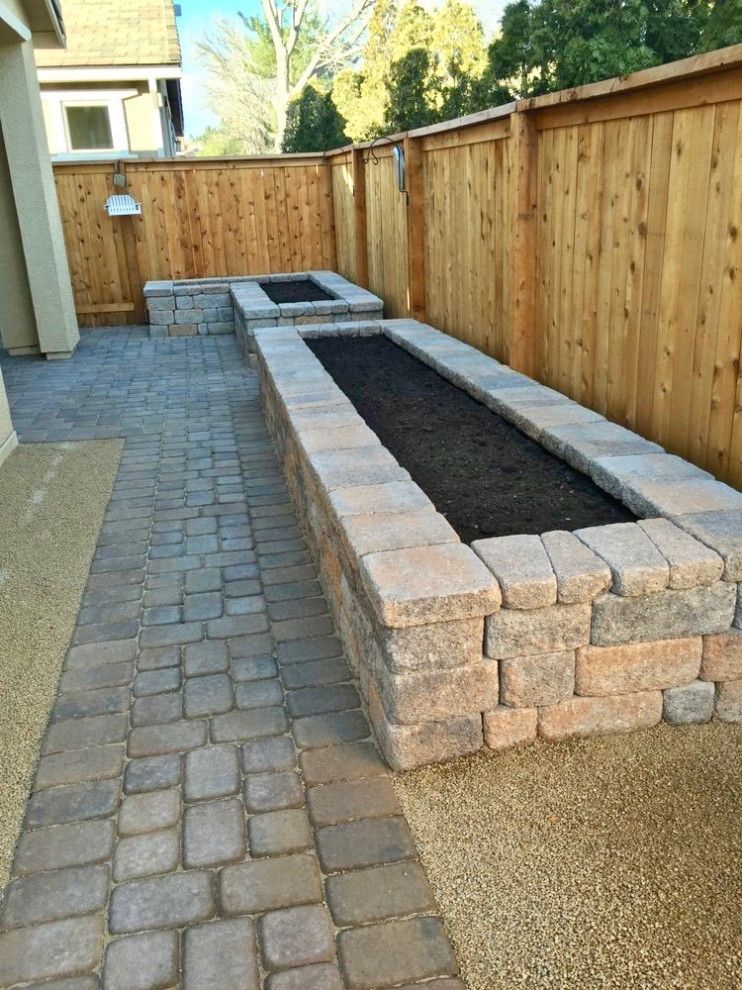 Design ideas for a mid-sized traditional backyard partial sun xeriscape for spring in Las Vegas with with raised garden bed and brick pavers.