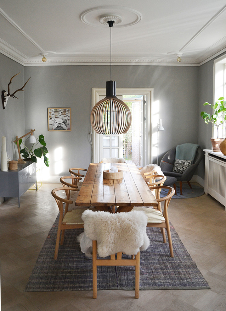 Large scandinavian separate dining room in Copenhagen with no fireplace, grey walls and medium hardwood floors.