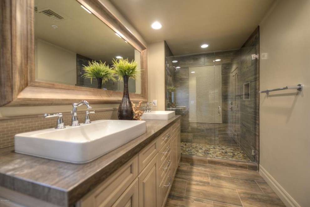 Photo of a mid-sized transitional 3/4 bathroom in Phoenix with raised-panel cabinets, beige cabinets, a curbless shower, a one-piece toilet, beige tile, ceramic tile, beige walls, travertine floors, a vessel sink and granite benchtops.