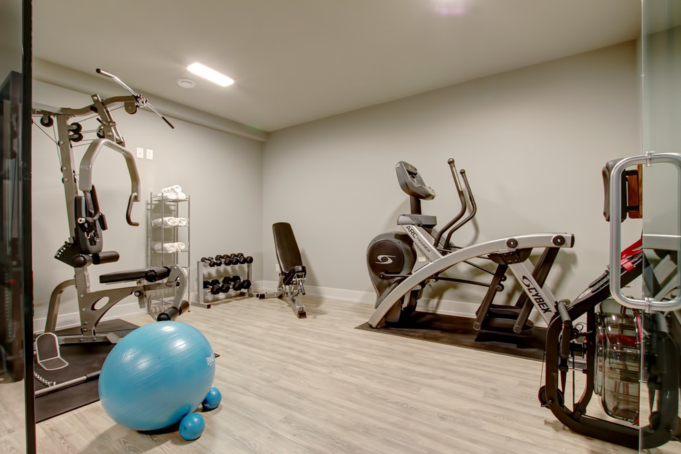 Small contemporary home weight room in Toronto with beige walls, light hardwood floors and beige floor.