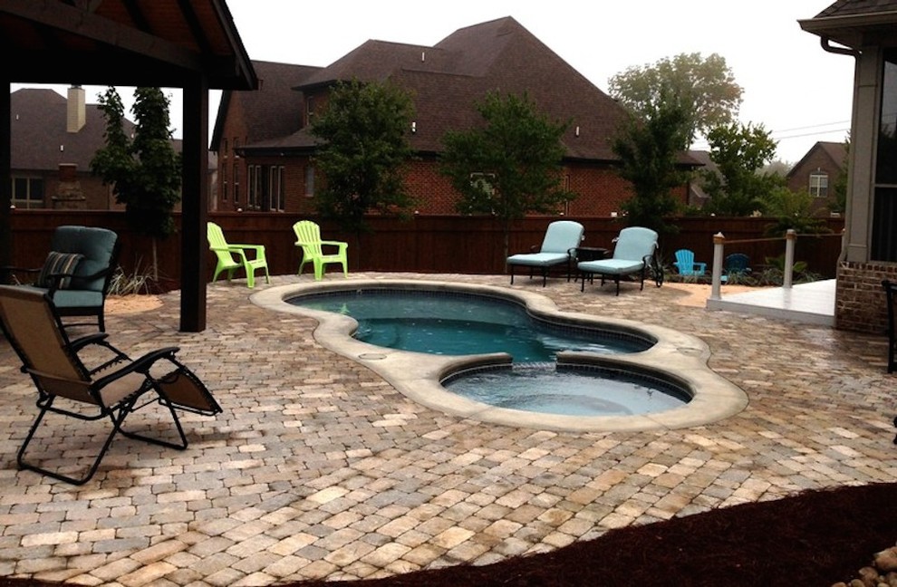 Inspiration for a mid-sized transitional backyard stamped concrete and custom-shaped hot tub remodel in Nashville