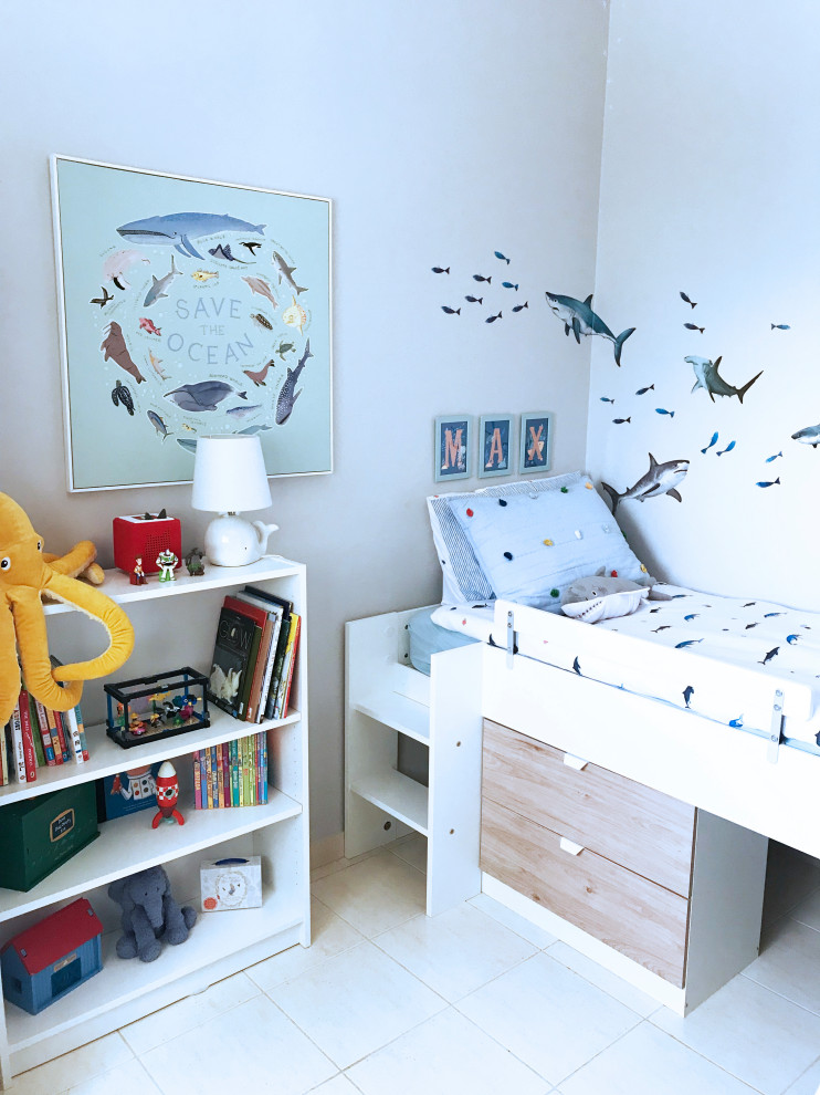 На фото: детская среднего размера в стиле неоклассика (современная классика) с спальным местом, серыми стенами, полом из керамогранита и бежевым полом для ребенка от 1 до 3 лет, мальчика