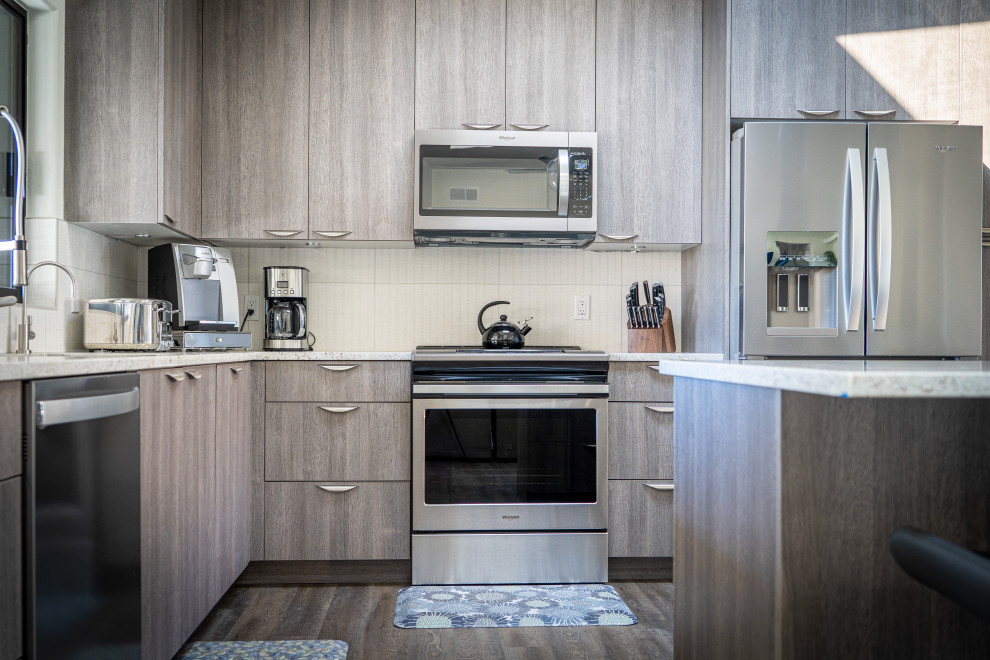 Example of a trendy kitchen design in Phoenix with flat-panel cabinets, gray cabinets, stainless steel appliances and an island