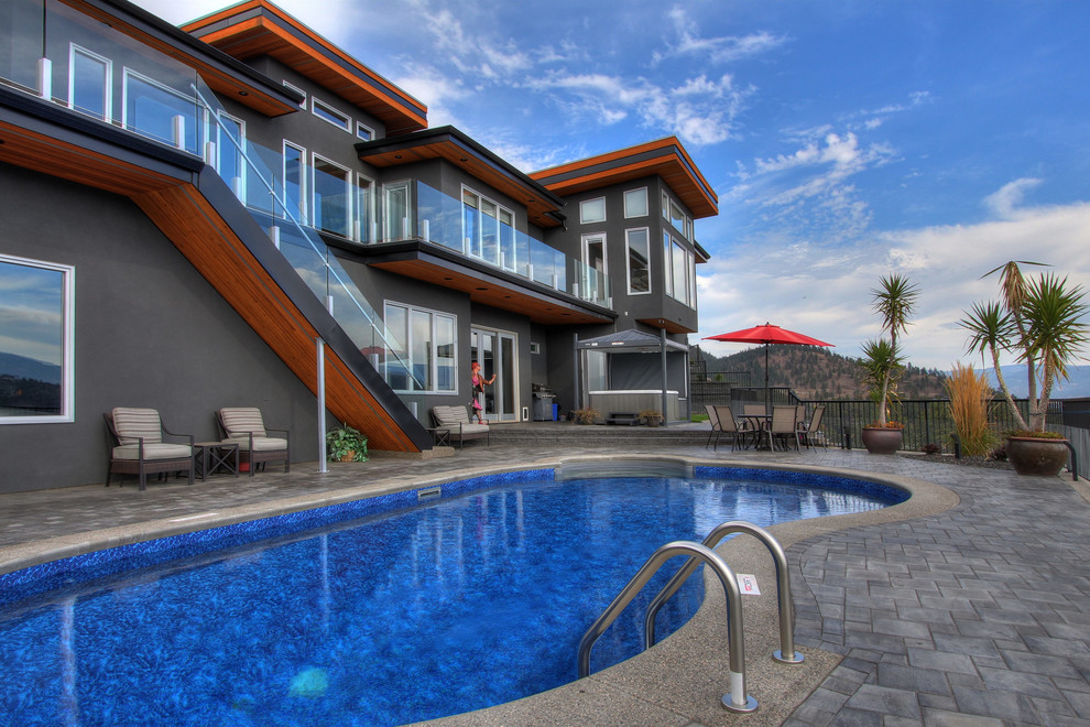 Inspiration for a mid-sized modern backyard kidney-shaped lap pool in Vancouver with tile.