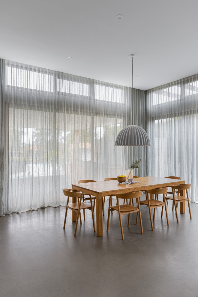 Esempio di una sala da pranzo minimalista con pavimento in cemento e pavimento grigio