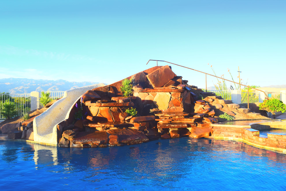Large backyard concrete paver and custom-shaped hot tub photo in Phoenix