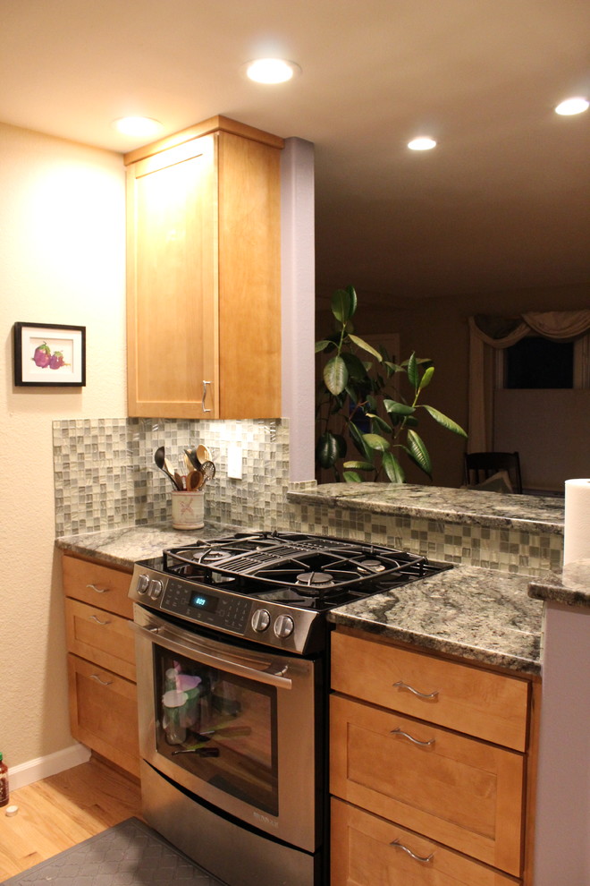 Inspiration for a small transitional light wood floor kitchen remodel in Denver with an undermount sink, recessed-panel cabinets, light wood cabinets, granite countertops, green backsplash, glass tile backsplash, stainless steel appliances and no island